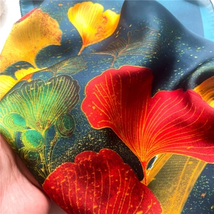 Detail of colorful ginkgo leaf patterns on premium silk square scarf with blue base