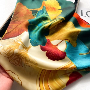 Detailed close-up of colorful ginkgo leaf patterns on premium silk scarf fabric