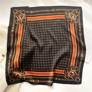 Elegant black silk scarf with orange equestrian belt and chain pattern on white texture