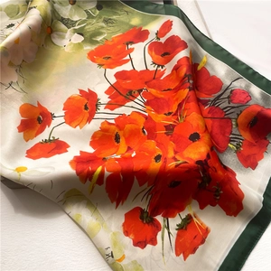 Detail of silk-like floral square scarf with red poppy print and green border