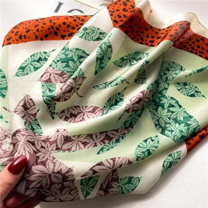 Silk scarf with green leaf pattern and orange leopard print accents for women