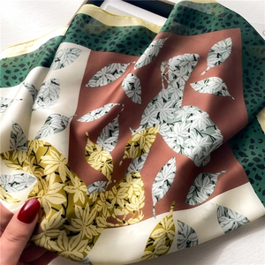 Detail of silk scarf with leopard print and autumn leaf patterns in earthy tones