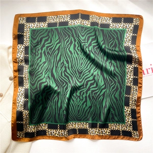 Detail of silk square scarf featuring leopard print, zebra patterns and gold chain motifs