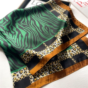 Chic silk scarf featuring green zebra, leopard prints and golden chain patterns