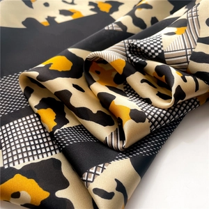 Macro view of leopard print silk scarf with black and white geometric patterns