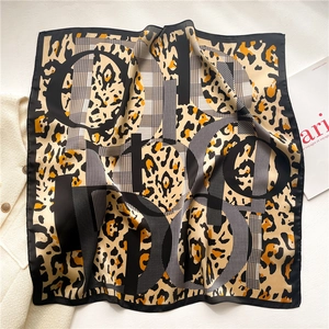Detail of silk-feel leopard print scarf featuring large letters and smooth texture