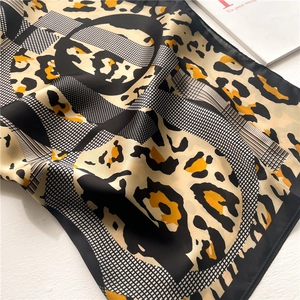 Detail of leopard print silk scarf with smooth satin finish and geometric patterns