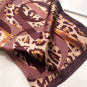 Close-up of silk-satin scarf texture showing leopard print and geometric patterns