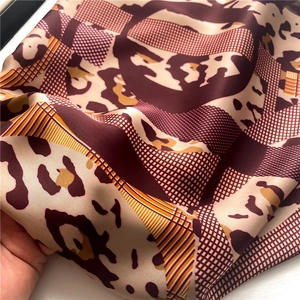 Detail of luxurious leopard and geometric print silk scarf with glossy texture
