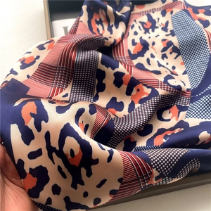 Close-up of silk scarf showing leopard print and abstract geometric color blocks