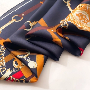 Macro shot of silk scarf detailing equestrian patterns with chains and stirrups