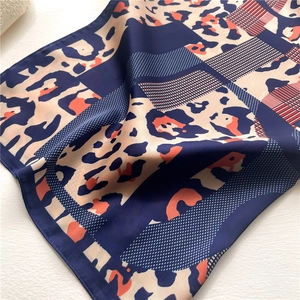 Detailed view of leopard print silk scarf showing fine rolled edges and smooth texture