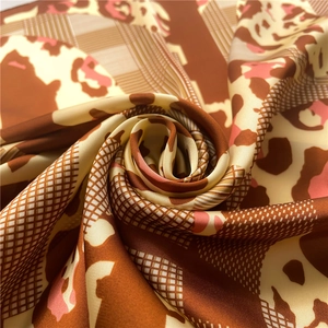 Detailed view of silk-like leopard print scarf folded in an elegant rose shape texture