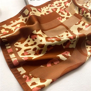 Macro detail of leopard print silk scarf with fine texture and glossy satin finish