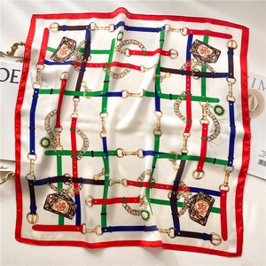 Detail of luxury silk scarf showing intricate chain patterns and smooth satin texture
