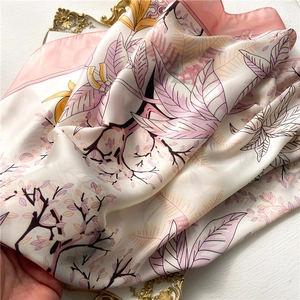 Carré de soie rose élégant avec motif floral peint à la main sur un plateau doré
