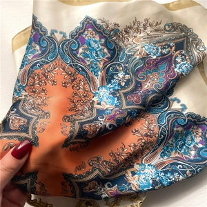 Detailed close-up of retro paisley print silk scarf with luxury blue floral patterns