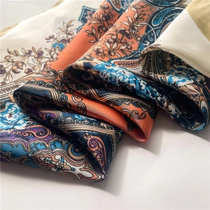 Macro view of silky satin scarf with paisley prints and bohemian flower details