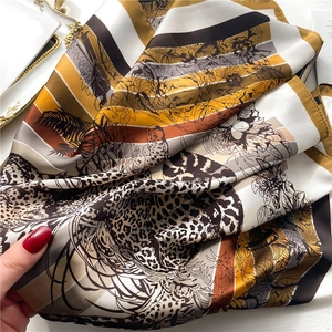 Detail of silk scarf with leopard print, floral patterns and yellow striped textures