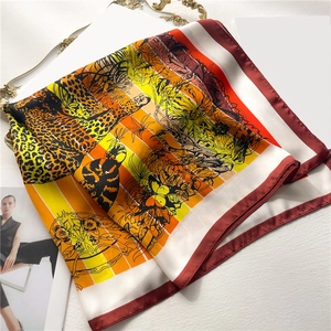 Silk-like square scarf featuring a tropical leopard and parrot print with red borders