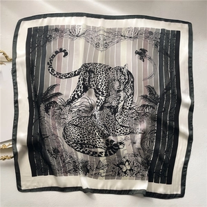 Close-up of leopard and tropical plant patterns on high-quality square silk scarf