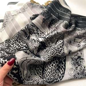 Detailed close-up of leopard and floral silk scarf with soft drape and satin luster