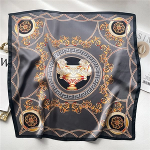 Detailed view of silk square scarf featuring grey baroque patterns and golden chain motifs