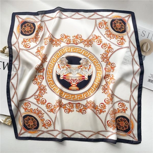 Macro detail of silk scarf featuring baroque lion head and gold Greek Key patterns