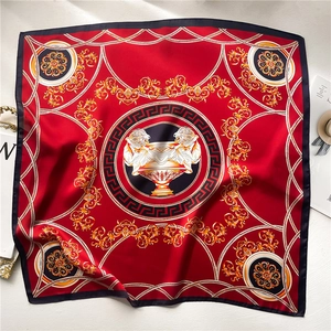 Red silk scarf with golden lion motifs and baroque patterns in a flat lay display