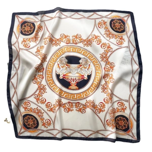 Baroque style silk scarf featuring golden lion head and chain patterns on white