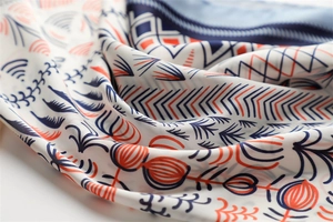 Macro view of geometric pattern and soft twill texture on a navy and orange silk scarf