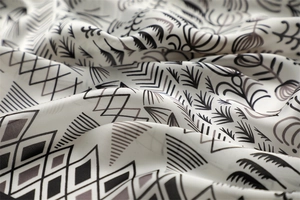 Detailed view of black and white geometric silk scarf with satin texture and soft drape