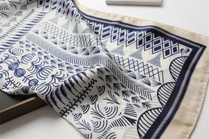 Detailed view of luxury satin square scarf with navy blue geometric patterns and golden borders