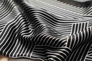 Macro detail of the smooth striped silk texture and elegant drape of the striped square scarf