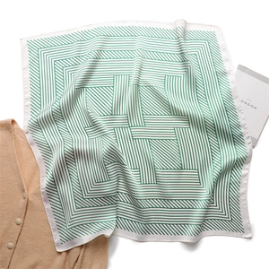 Detail of green and white striped square silk scarf showing satin texture and geometric pattern