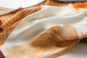 Macro detail of silk scarf showing floral print and elegant satin texture folds