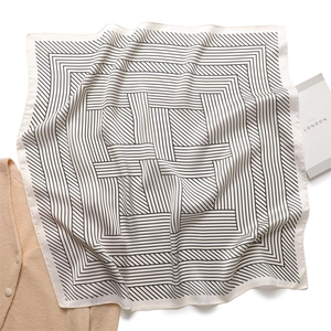Flat lay of a 70cm square silk scarf with black and white geometric maze stripes