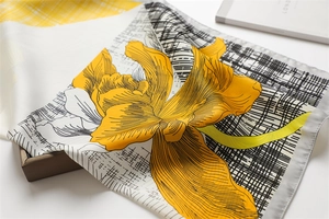 Detail of yellow flower pattern on checkered silk scarf over a lifestyle book