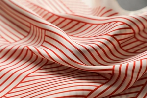 Detailed view of red and white striped satin fabric with smooth texture and soft folds