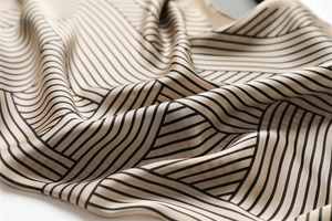 Detail view of the silk-like fabric texture with elegant black geometric stripes