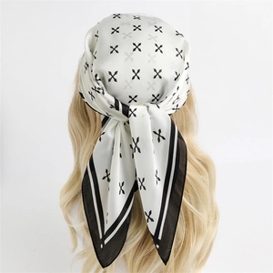 Carré de soie minimaliste noir et blanc porté en bandeau sur des cheveux blonds