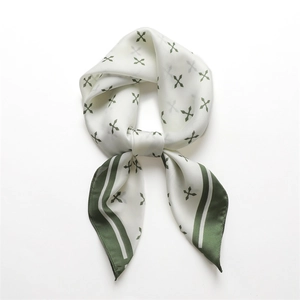 Détail de la texture satinée et des motifs de trèfles verts sur le foulard carré en soie