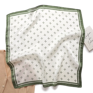 Détail du tissu en soie avec motif floral vert et coutures d'ourlet élégantes de l'écharpe