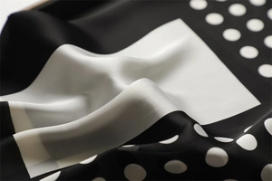 Macro shot of high-quality black and white polka dot silk scarf texture and glossy finish