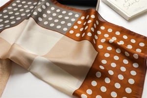 Macro view of silky polka dot square scarf with geometric patchwork and brown tones