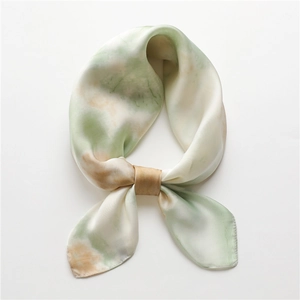 Détail d'un foulard carré en soie noué en boucle avec motif peinture à l'huile vert et beige