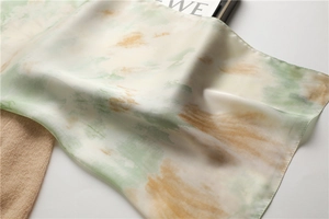 Détail du foulard en soie avec dégradé aquarelle, bords roulés et brillance satinée
