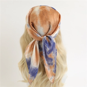 Carré de soie tie-dye bleu et orange porté comme bandeau bohème élégant pour femmes