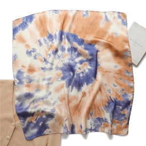 Foulard en soie style peinture à l'huile bleu et orange sur un pull en maille beige
