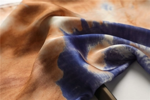 Macro d'un foulard en soie avec motif peinture à l'huile, texture satinée et design tie-dye